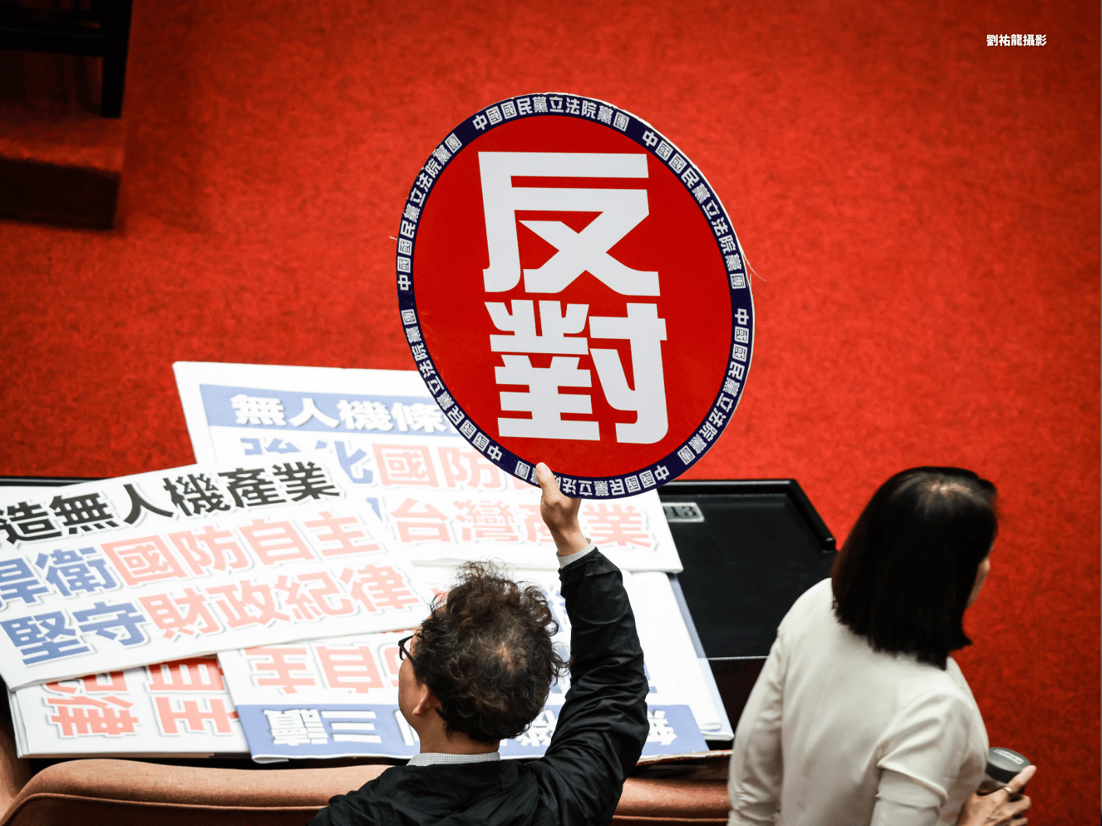 對於民進黨團所提修正案,國民黨團立委高舉「反對」舉牌,提醒同黨立委投票立場。(劉祐龍攝影)