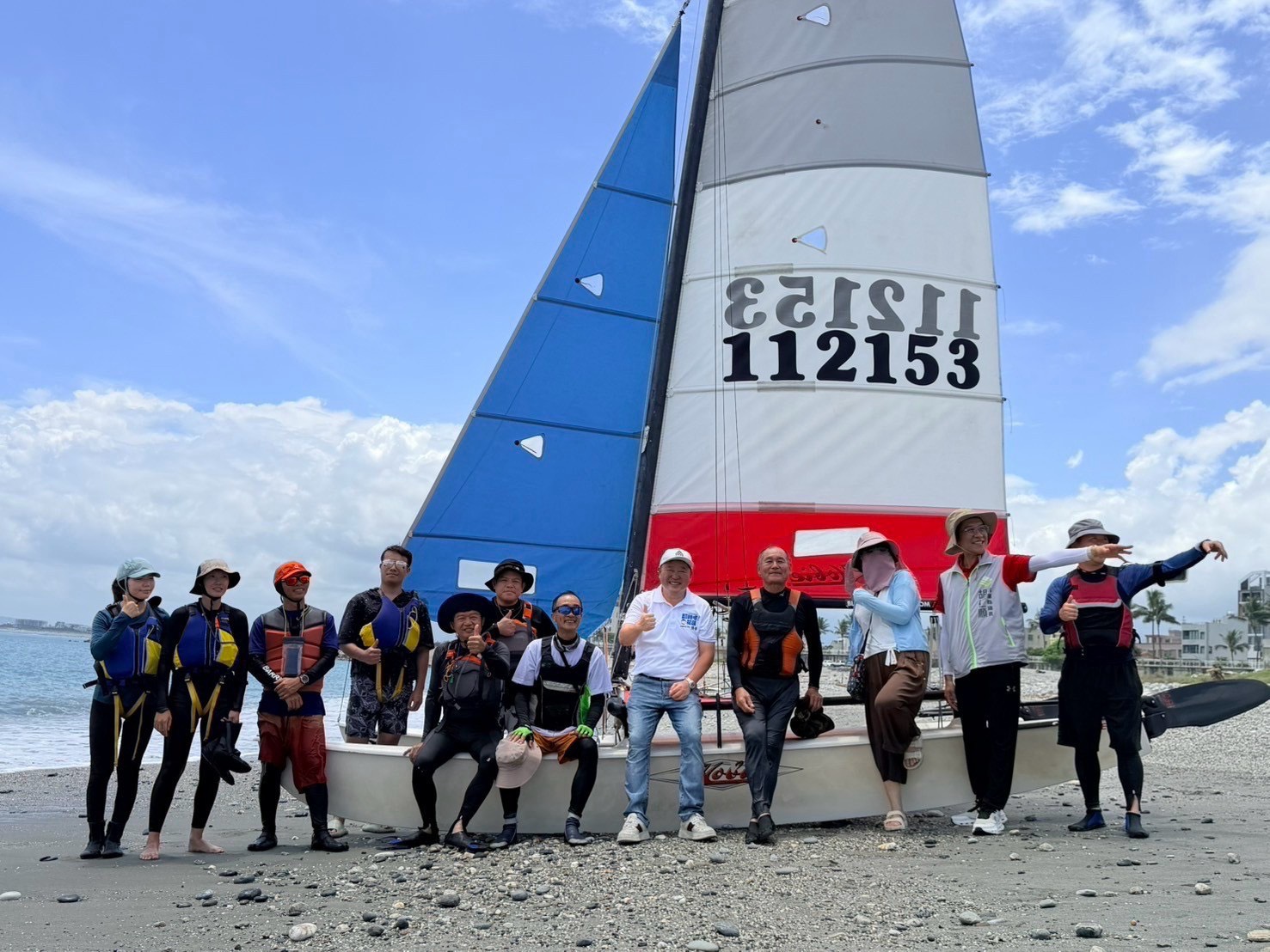張峻(右五)今(29)日在縣議員胡仁順帶領下,前往花蓮市北濱海岸參與帆船體驗活動,與在地海洋運動愛好者交流。(圖/記者 趙靜姸翻攝)