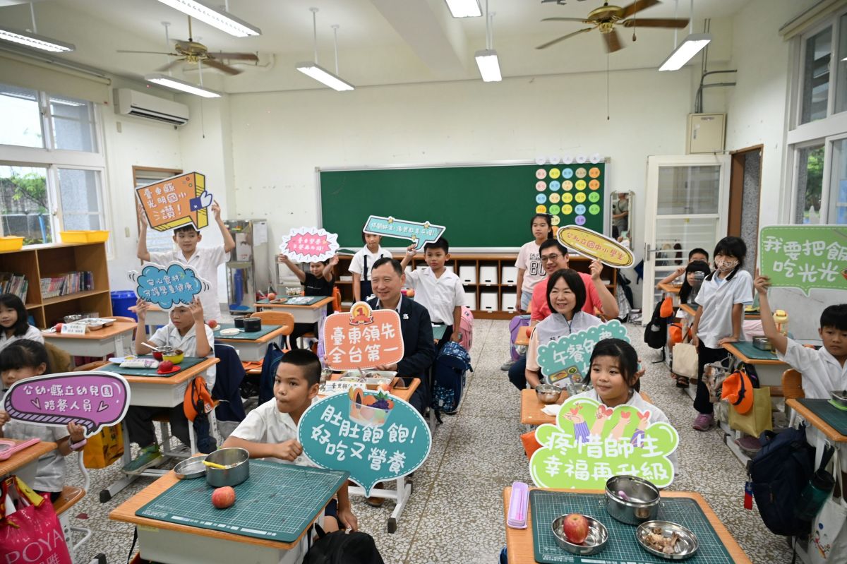 圖/副縣長王志輝與光明國小師生手持標語開心合影,歡慶臺東縣營養午餐免費補助擴大及餐費全面升級。(臺東縣政府提供)