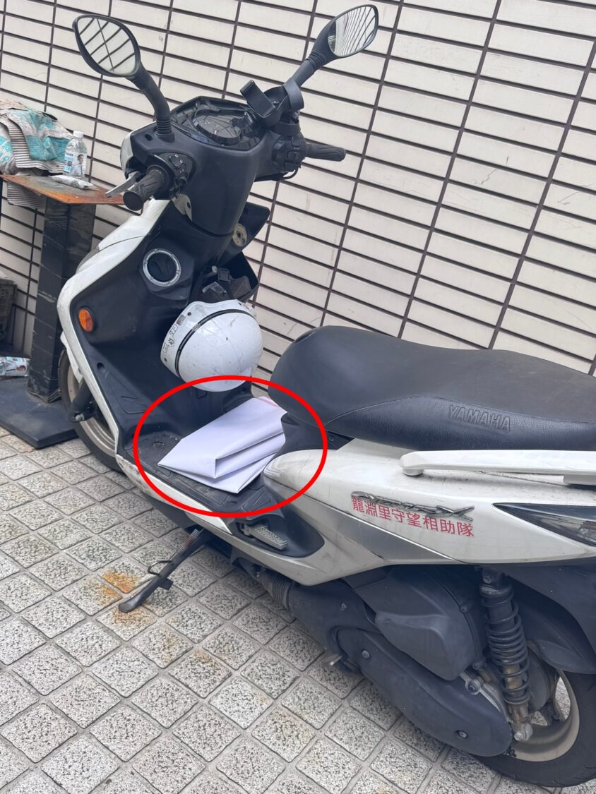 民眾拍下龍淵里現任里長汪吉秋撕毀海報後,放置機車踏墊上。(圖/林晏慈提供)