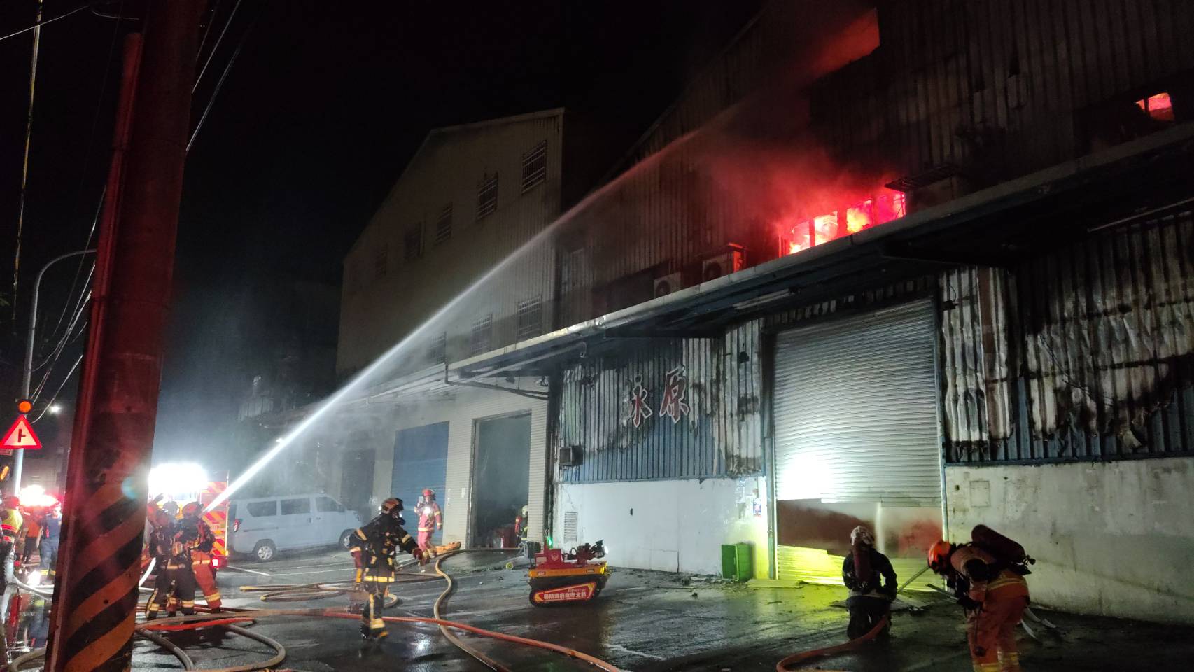 新北市新莊區新樹路268巷一處連棟鐵皮工廠,昨(23)日晚間11時15分發生嚴重火警,新北市消防局獲報後出動50輛救援車輛、115名消防人員趕赴現場投入搶救。(圖/記者 施立偉翻攝)