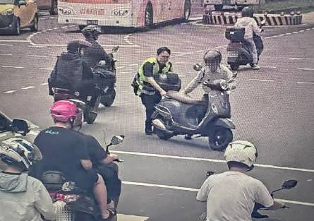 在場員警協助民眾推拋錨機車至路旁安全處。(圖/記者 戴昱弘翻攝)
