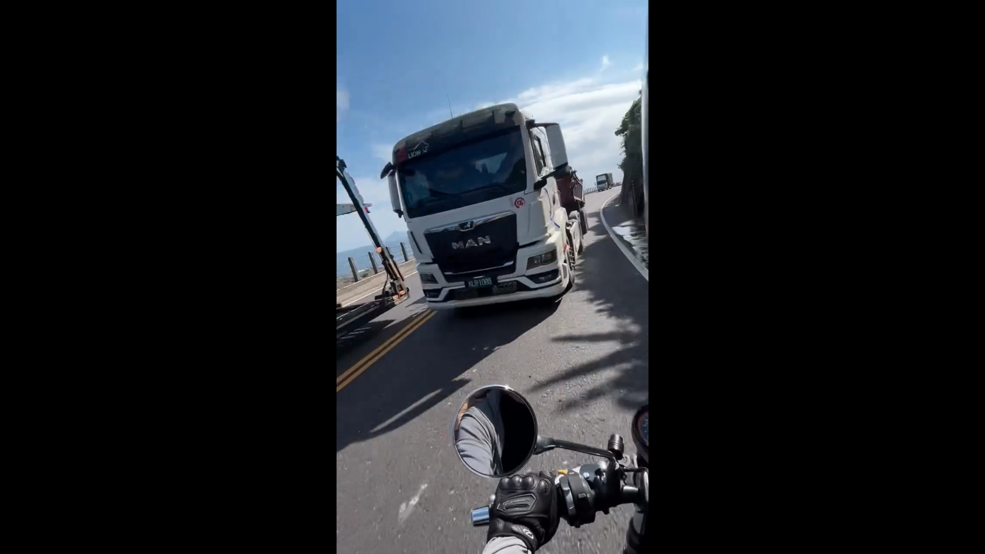 機車騎士行經台2線北部濱海公路時，遇砂石車疑似跨越雙黃線逆向超車，且事發位置位於彎道路段，驚險過程全被行車記錄器拍下。（圖／Threads @claydshort 授權提供）