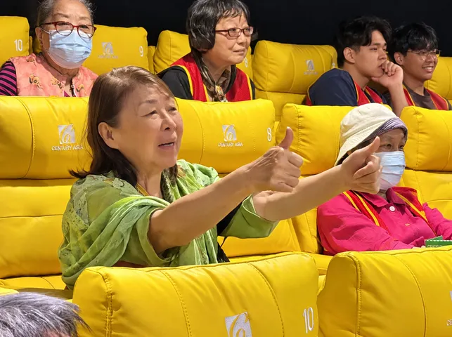 參加《沙央》公益首映會的長輩與台前熱情比讚互動（甲上娛樂提供）