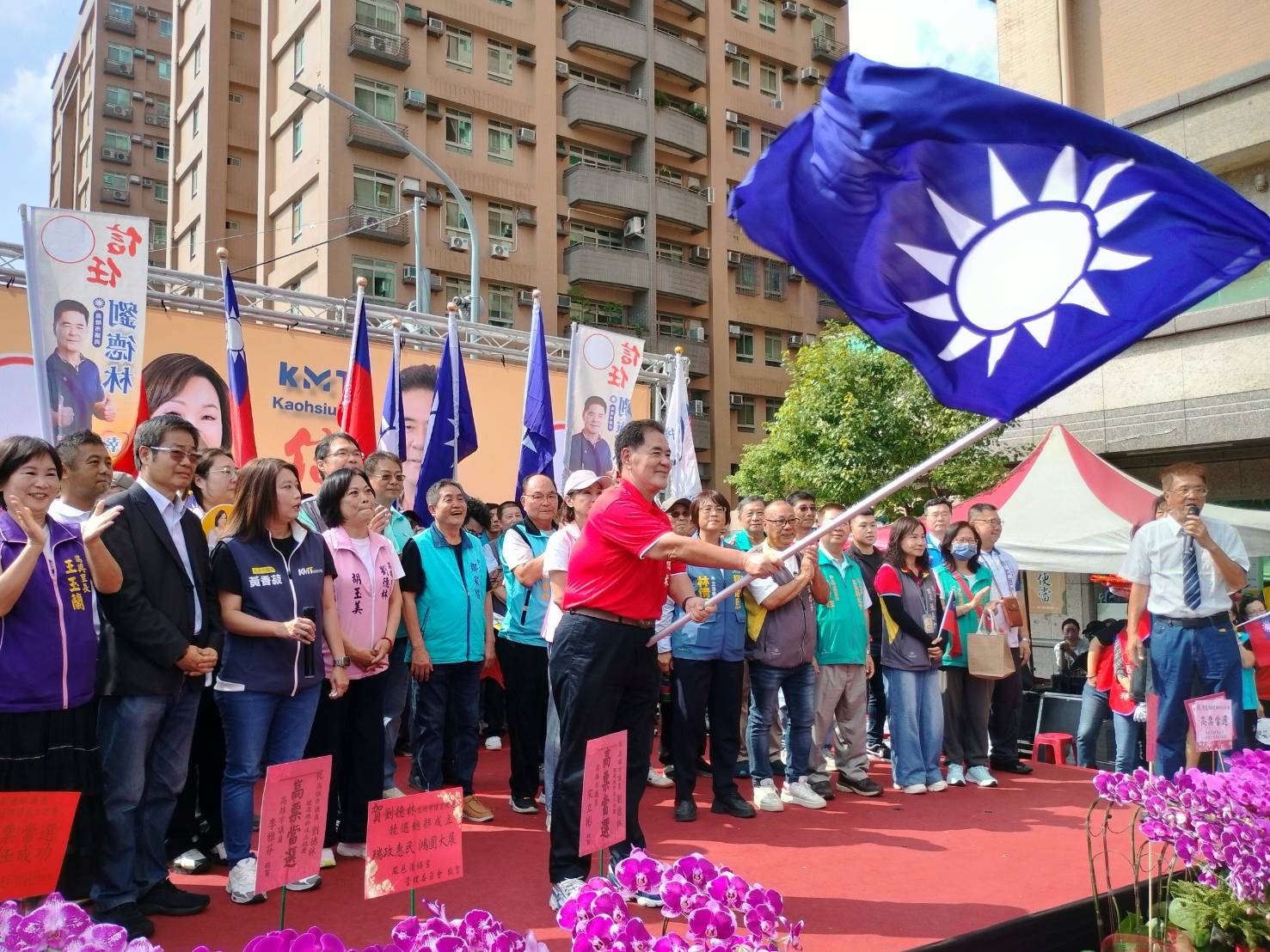 ▲市議員劉德林揮舞黨旗競選八連任。(記者 李堂安 翻攝)