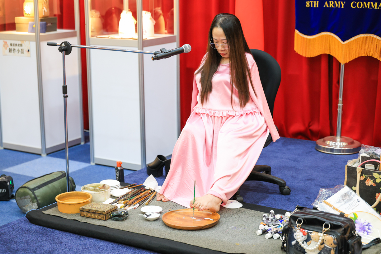 ▲楊恩典在現場以「腳」揮毫作畫,展現堅毅生命力與藝術才華,令眾人深受感動。(圖/陸軍八軍團提供)