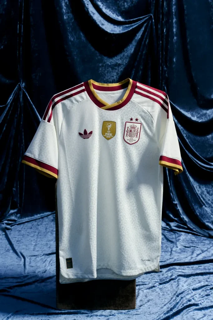 adidas西班牙隊「冠軍二星」以象牙白為基底，並搭配金色圖騰和酒紅色細節。