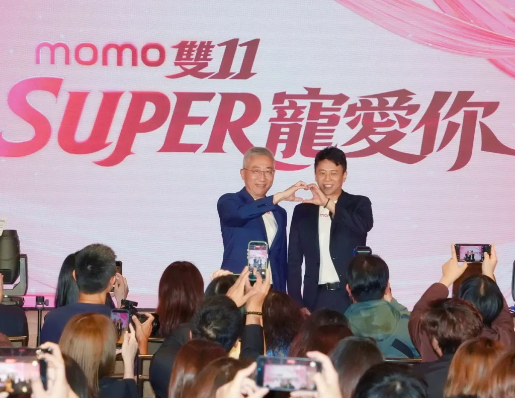momo富邦媒總經理谷元宏（圖左）與資深副總經理洪偉釗（圖右）復刻momo雙11大使SUPER JUNIOR-83z利特、希澈合體用手比愛心。